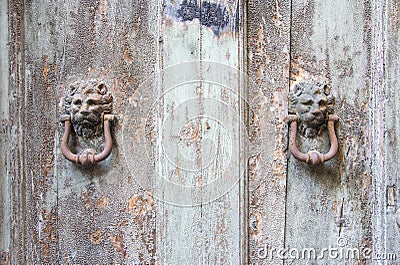 Lion head knockers on an old wooden door in Tuscany. Stock Photo